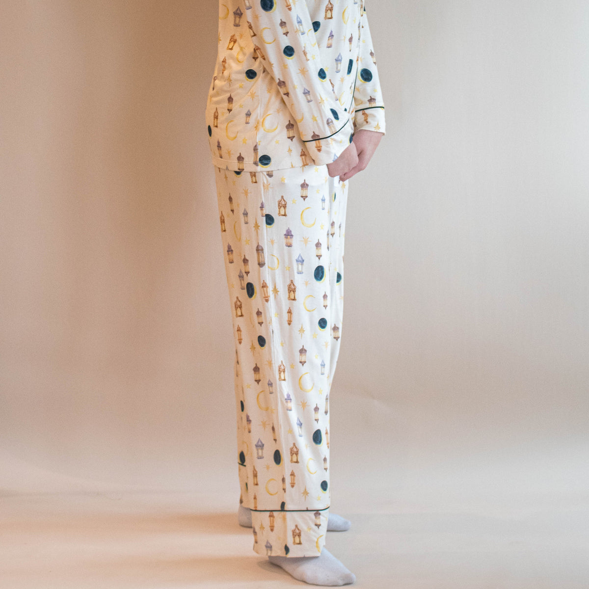 woman standing in pjs looking at camera moon and star lanterns all over pajamas