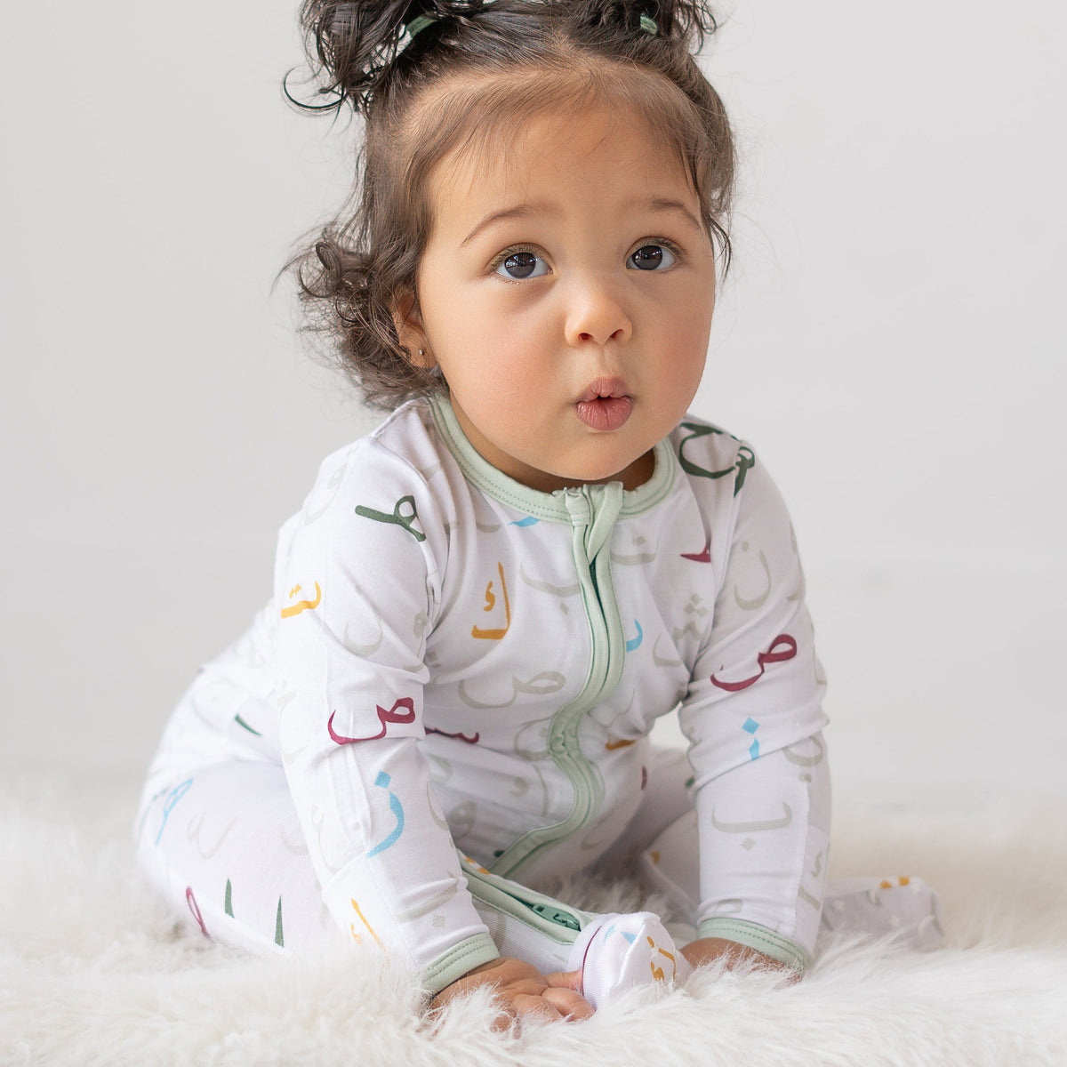 baby girl wear white onesie with arabic letters